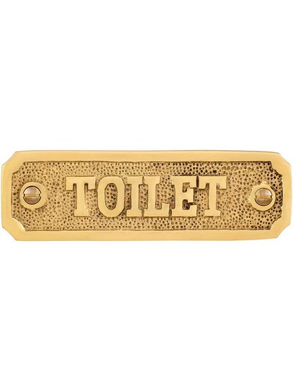 Cast Brass Toilet Sign in Polished Brass.